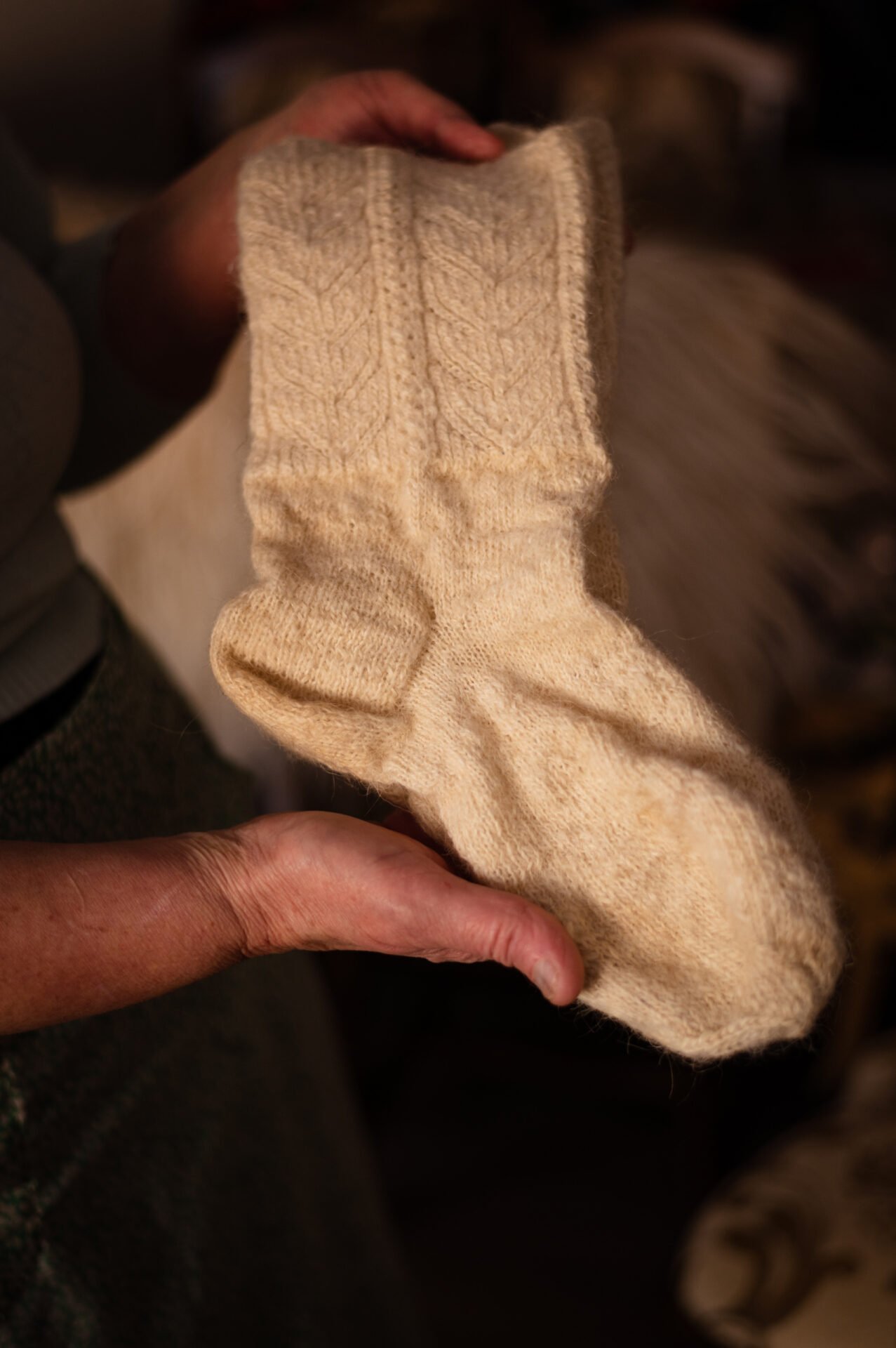 Maria Hotea, 55, smiles as she shows some traditional woolen socks she keeps in her home in Breb.